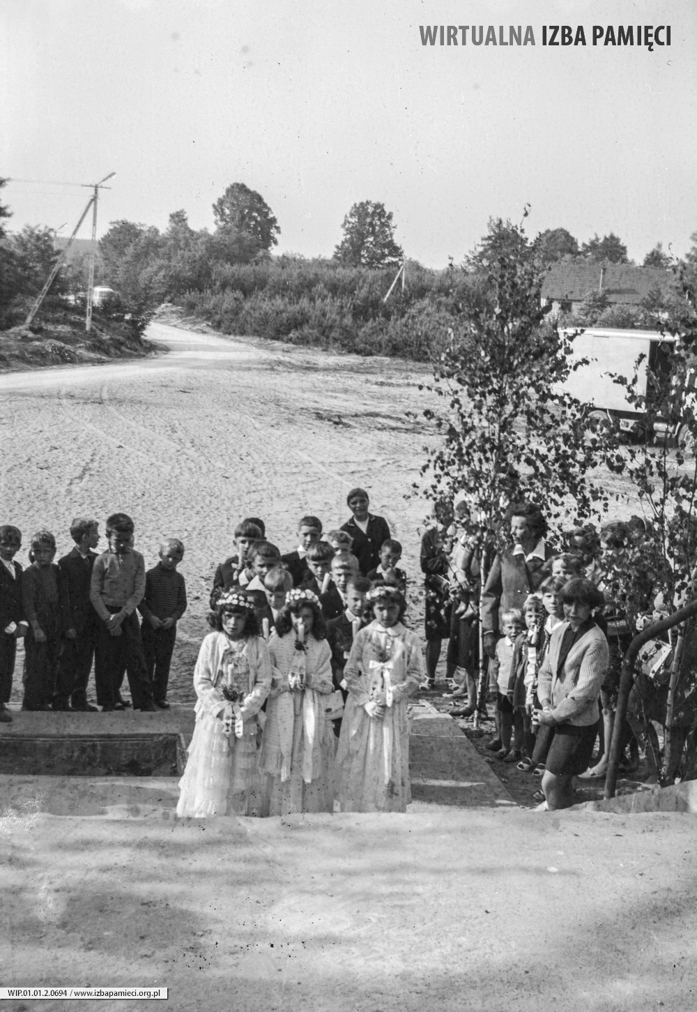 Lata 70. XX wieku. Dzieci pierwszokomunijne oczekują przed kościołem pw. Niepokalanego Serca NMP w Mołodyczu