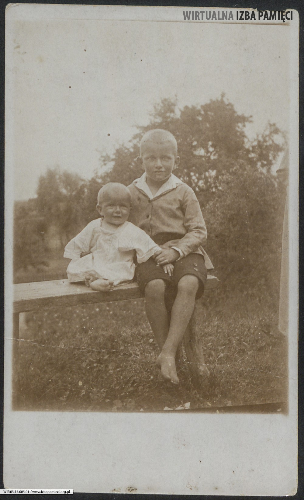 Lata 20. XX w. Fotografia dzieci siedzących na ławce.