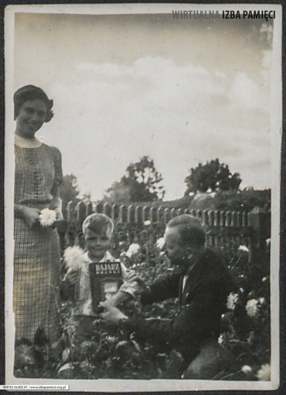 Lata 30. XX w. Fotografia kobiety i mężczyzny z dzieckiem w ogrodzie.