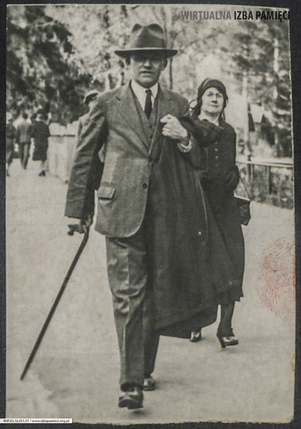 Lata 30. XX w. Fotografia mężczyzny z laską. W tle kobieta.