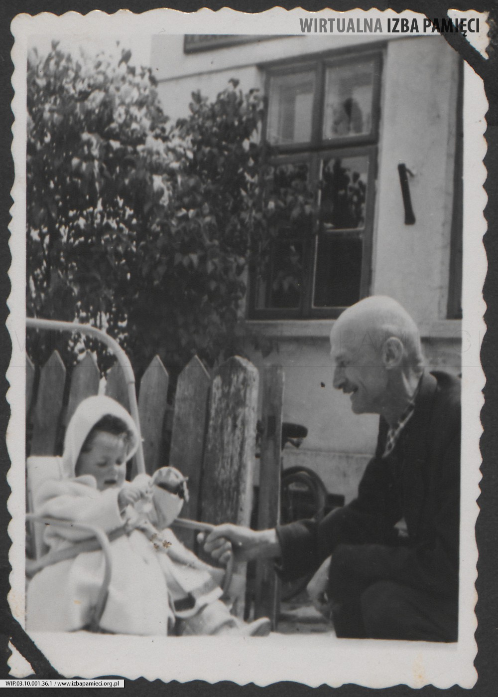 1950. Lubaczów. Barbara Gutowska w wózku z dziadkiem Władysławem Ruebenbauerem przed domem.