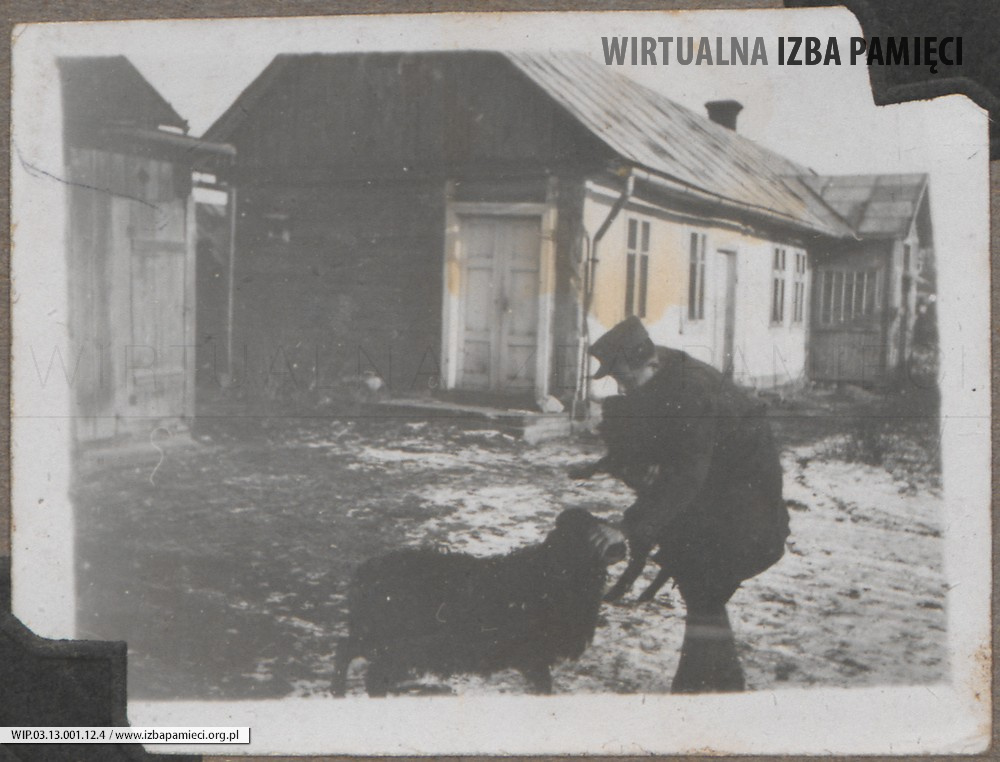 Lata 40. XX w. Lubaczów. Mężczyzna z psem na tle domu.
