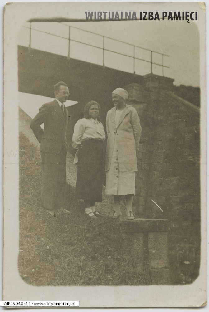 1936. Grupa osób na tle mostu kolejowego.