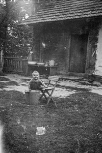 1960. Anna Wójtowicz przed domem z wiadrem wody 