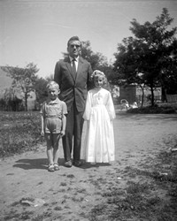 Lata 60. XX wieku. Dziewczynka w dniu I Komunii ze swoim ojcem i bratem