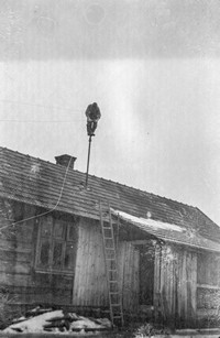 1971. Elektryk wykonuje przyłącz elektryczny na dachu domu w Mołodyczu
