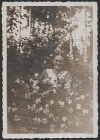 Lata 30. XX w. Fotografia kobiety wśród kwiatów.