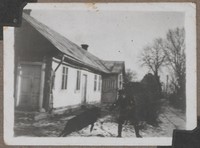 Lata 40. XX w. Lubaczów. Fotografia mężczyzny z psem na tle domu.