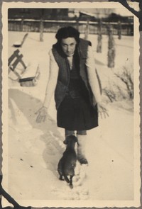1948. Lubaczów. Maria Gutowska podczas zabawy z psem na śniegu.