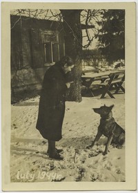 1944. Nierozpoznana kobieta w trakcie zabawy z psem.